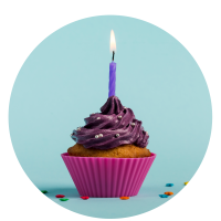 purple-burning-candles-decorative-muffins-with-colorful-star-sprinkles-against-blue-backdrwop